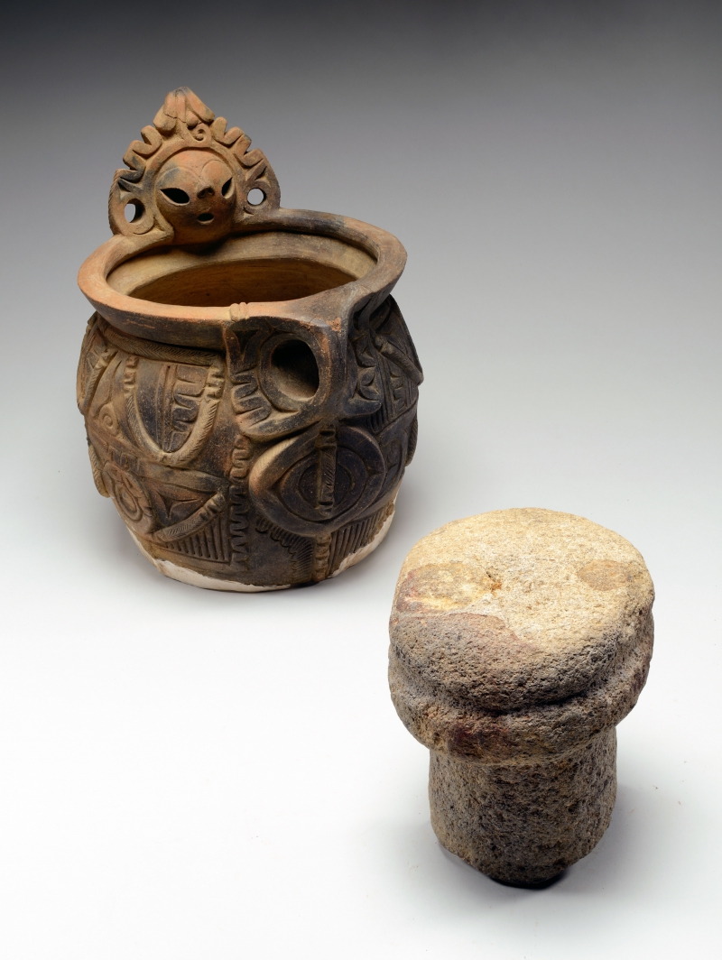 Pottery decorated with a human face and a stonerod